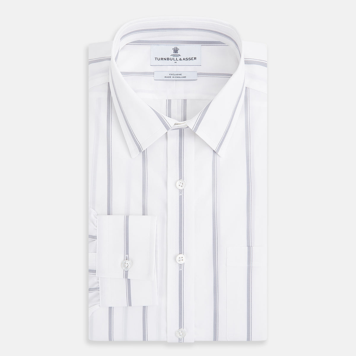 View 5 of product Introducing the Track Striped Grey on White Weekend Fit Shirt in Cotton by Turnbull & Asser UK—a men’s long-sleeve dress shirt crafted from crisp white cotton, featuring vertical grey stripes, a button-down front, derby collar, cuffs, and a chest pocket. The shirt is displayed laid flat on a white surface.