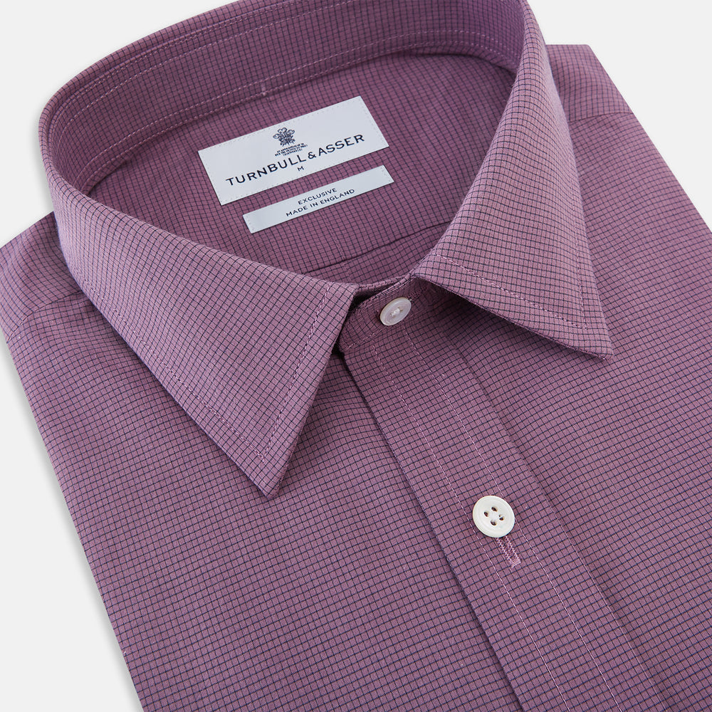 A long-sleeve, button-up pure cotton shirt—the Striped Navy on Antique Pink Weekend Fit Shirt by Turnbull & Asser UK—features subtle navy stripes on antique pink, a front chest pocket, white buttons, and a classic collar, displayed on a white background—a timeless nod to English shirtmaking.