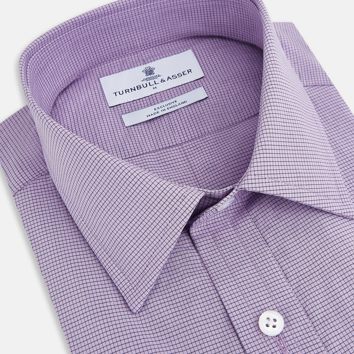 View 2 of product A long-sleeved, button-up Fine Checked Baby Pink Weekend Fit Shirt in Cotton by Turnbull & Asser UK, featuring a single chest pocket and a classic collar design, laid flat on a white background.