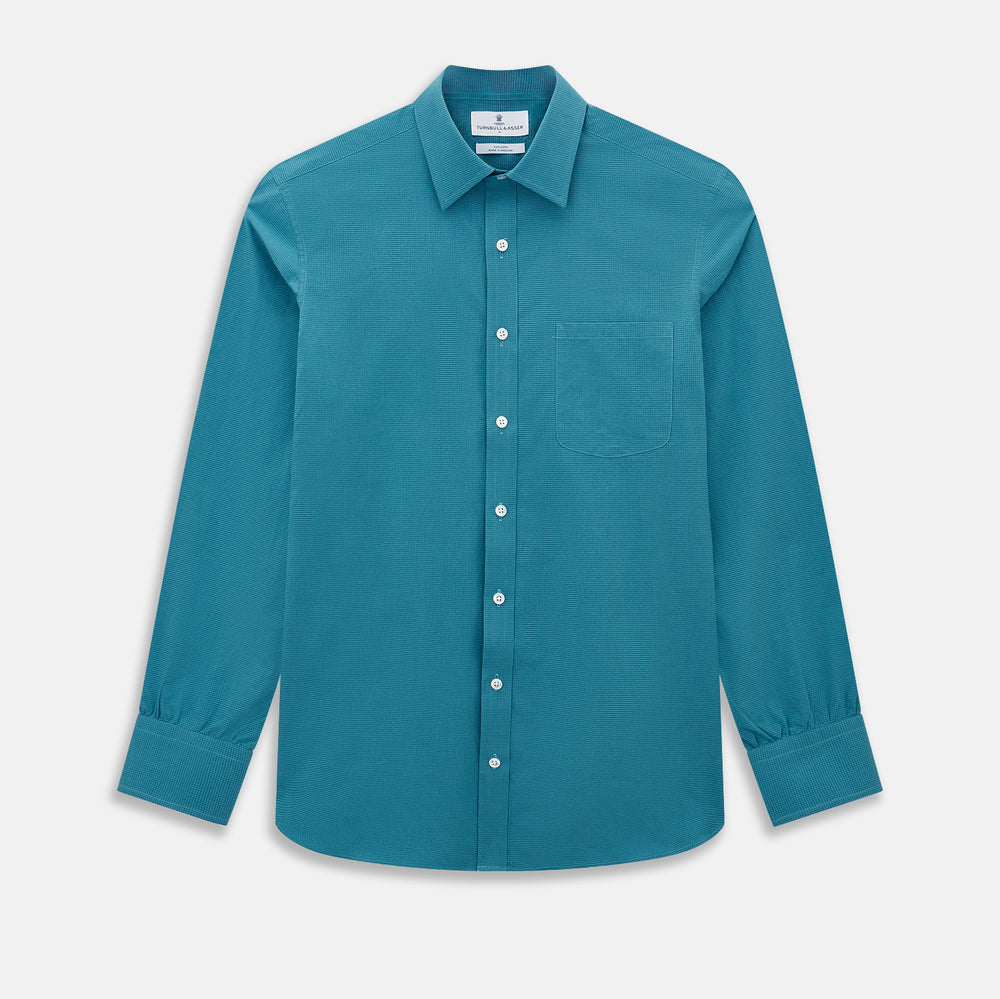 Here’s a rewritten version using your product data: The Turnbull & Asser UK Fine Checked Turquoise Blue Weekend Fit Shirt in Cotton is a men’s long-sleeve button-up, featuring a chest pocket, white buttons, and a pointed collar, shown laid flat against a white background.