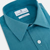 View 2 of product Here’s a rewritten version using your product data: The Turnbull & Asser UK Fine Checked Turquoise Blue Weekend Fit Shirt in Cotton is a men’s long-sleeve button-up, featuring a chest pocket, white buttons, and a pointed collar, shown laid flat against a white background.