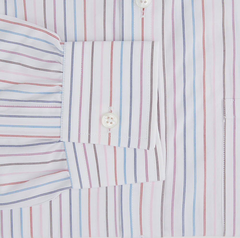 The Turnbull & Asser Multi Pencil Stripe Richmond Shirt features long sleeves, a Derby collar, left chest pocket, and light blue, red, and white pencil stripes. It is laid flat on a white background.