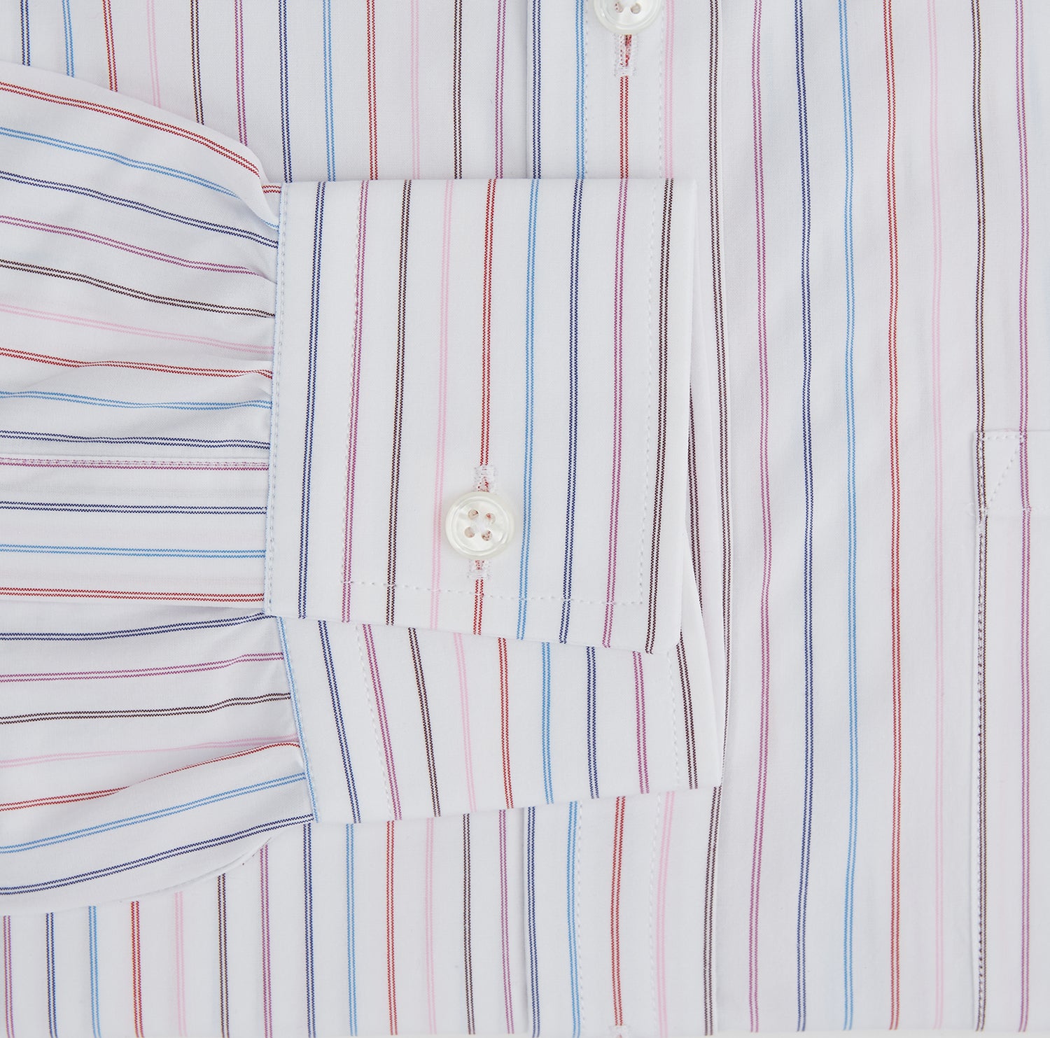 View 3 of product The Turnbull & Asser Multi Pencil Stripe Richmond Shirt features long sleeves, a Derby collar, left chest pocket, and light blue, red, and white pencil stripes. It is laid flat on a white background.