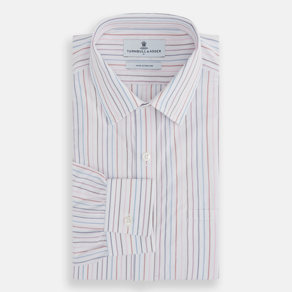 The Turnbull & Asser Multi Pencil Stripe Richmond Shirt features long sleeves, a Derby collar, left chest pocket, and light blue, red, and white pencil stripes. It is laid flat on a white background.