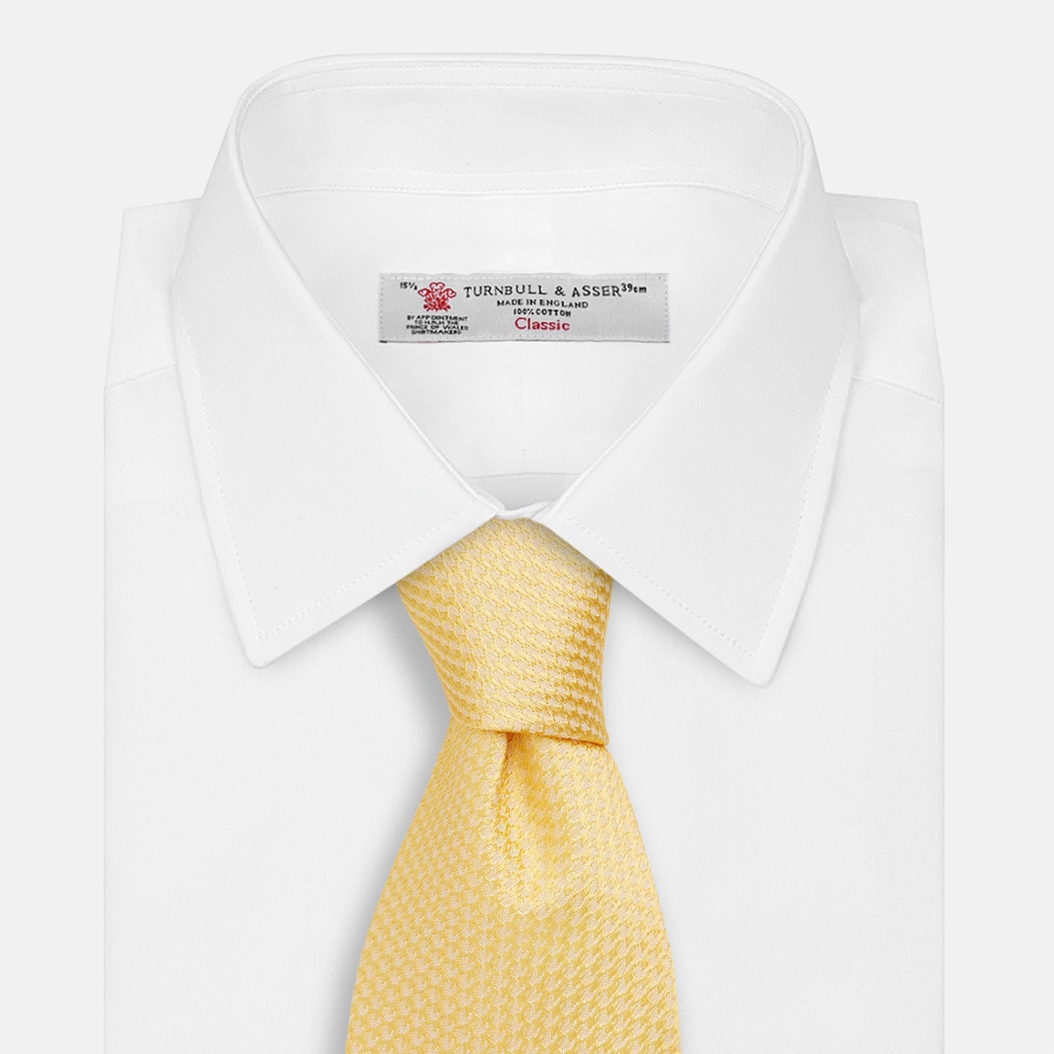 View 2 of product The Turnbull & Asser Yellow Lace Silk Tie, featuring a light yellow hue and subtle texture, is neatly rolled and displayed on a plain white background.