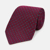 View 1 of product A rolled-up Turnbull & Asser Green and Magenta Micro Dot Silk Tie, featuring small, evenly spaced magenta dots on green silk, displayed on a plain white background—an ideal accessory for sophisticated outfits.