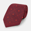 View 1 of product A rolled Tulip Red Concentric Diamond Printed Silk Tie in red silk featuring a dark blue concentric diamond pattern.