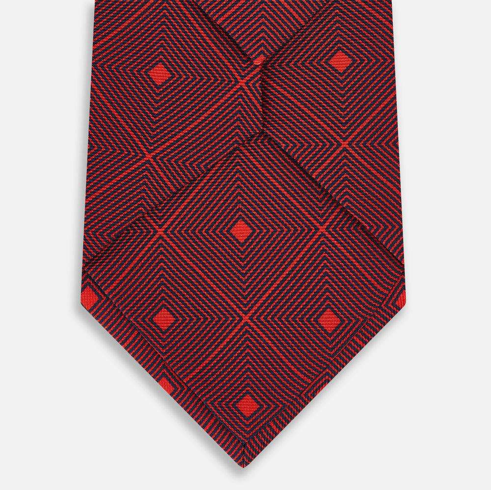 A rolled Tulip Red Concentric Diamond Printed Silk Tie in red silk featuring a dark blue concentric diamond pattern.