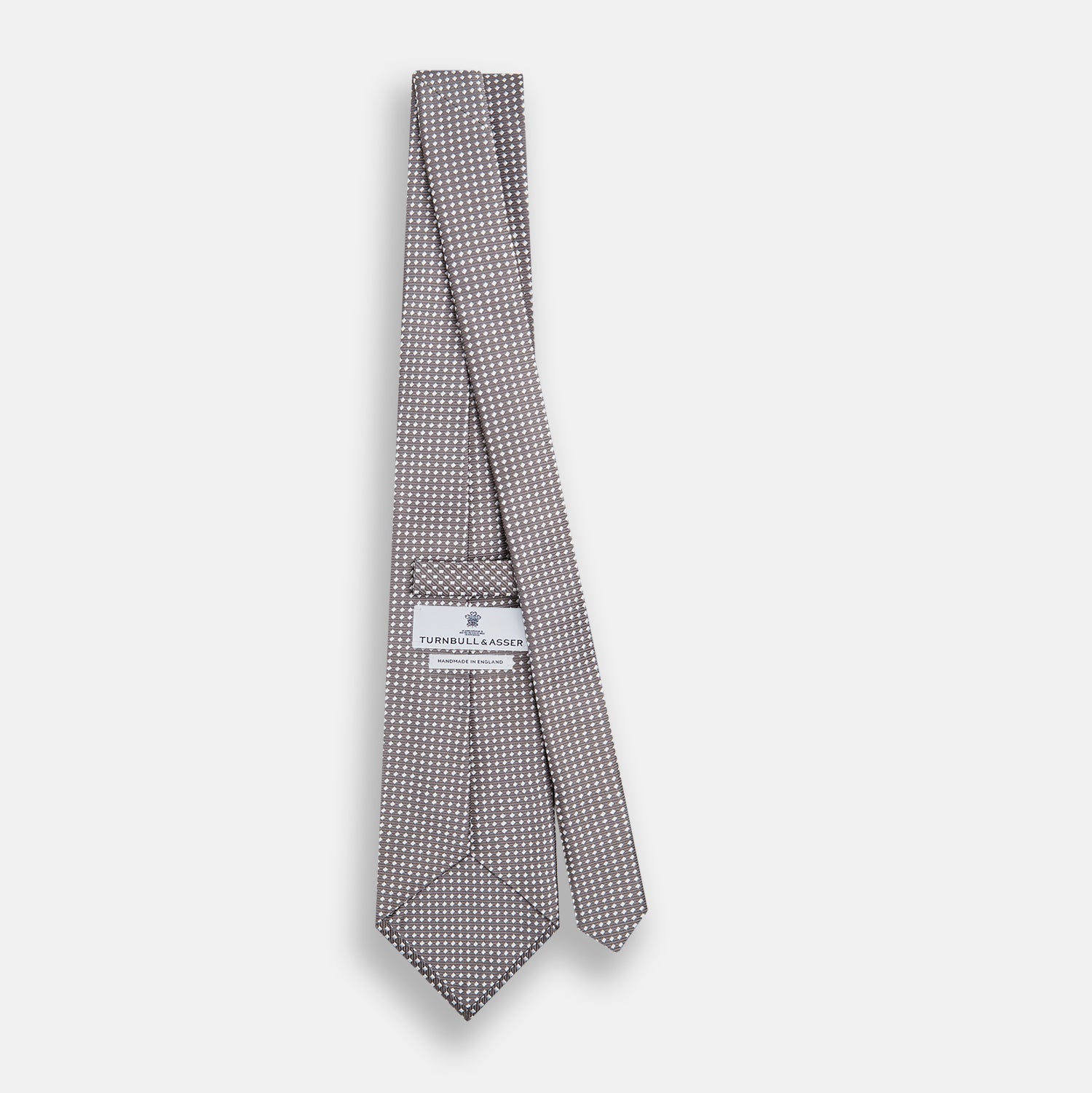 View 4 of product The Turnbull & Asser Grey and White Diamond Silk Tie features a refined geometric pattern, combining silver triangles on a white background for an elegant look.