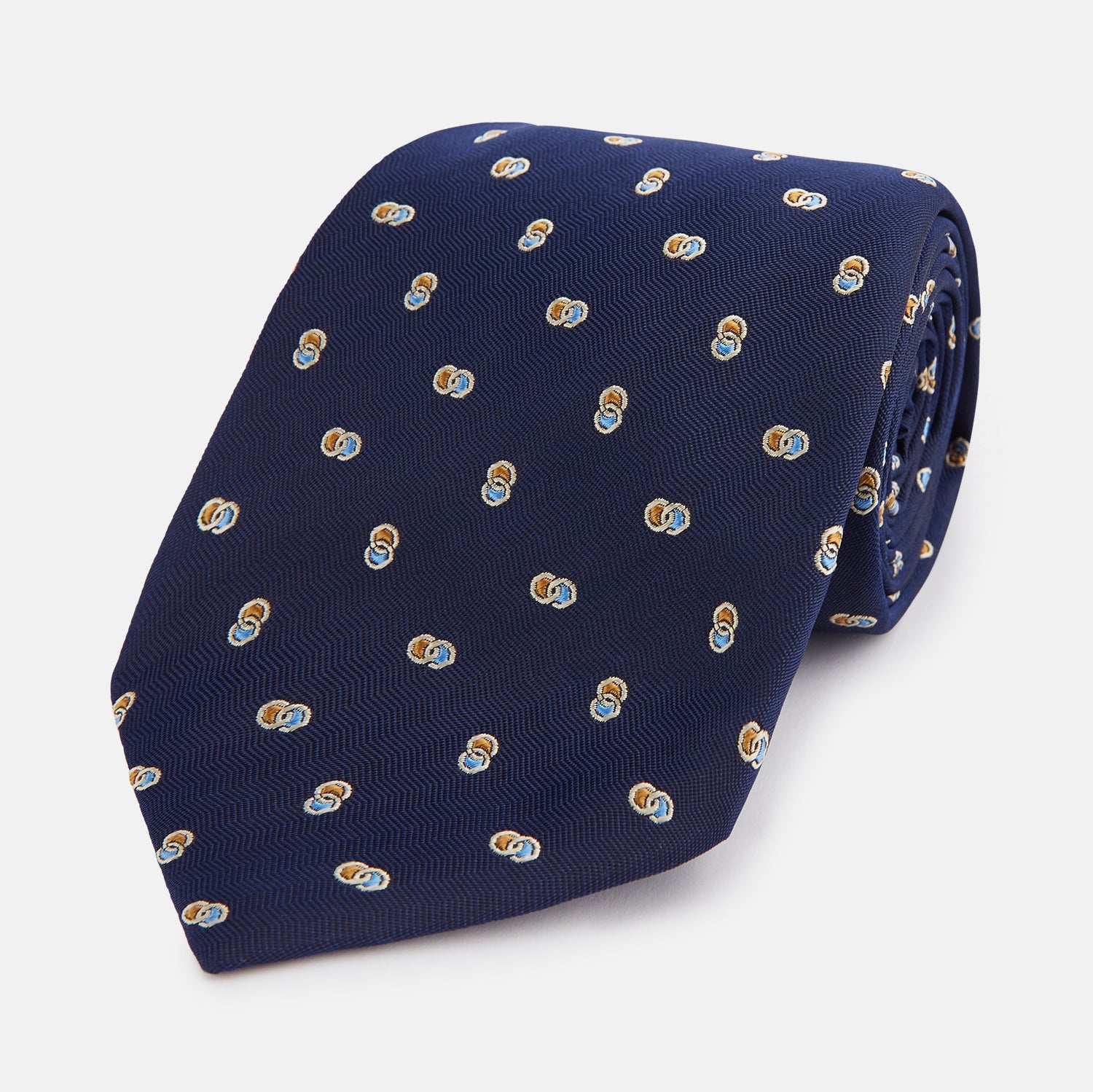 View 1 of product The Turnbull & Asser Blue and Yellow Links Silk Tie features a refined zigzag texture and a repeating pattern of interlocking gold and blue rings—the perfect sophisticated accent for the modern gentleman, especially paired with Turnbull & Asser shirts.