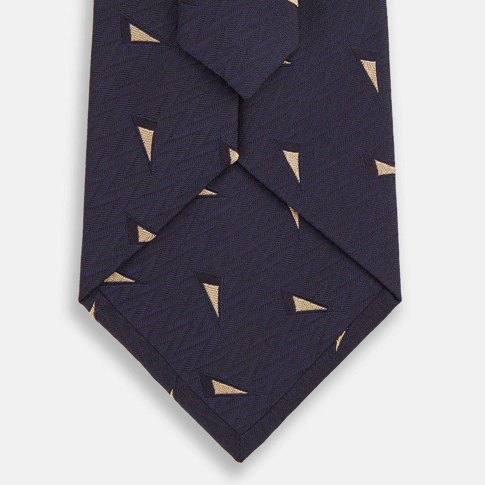 The Navy Triangle Silk Tie by Turnbull & Asser features an elegant gold micro triangle pattern on navy silk, making it a sophisticated accessory that pairs perfectly with Turnbull & Asser shirts.