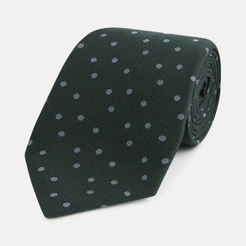 The Turnbull & Asser Pale Blue and Green Micro Dot Silk Blend Tie, shown rolled on a white background, is ideal for complementing your favorite shirts.