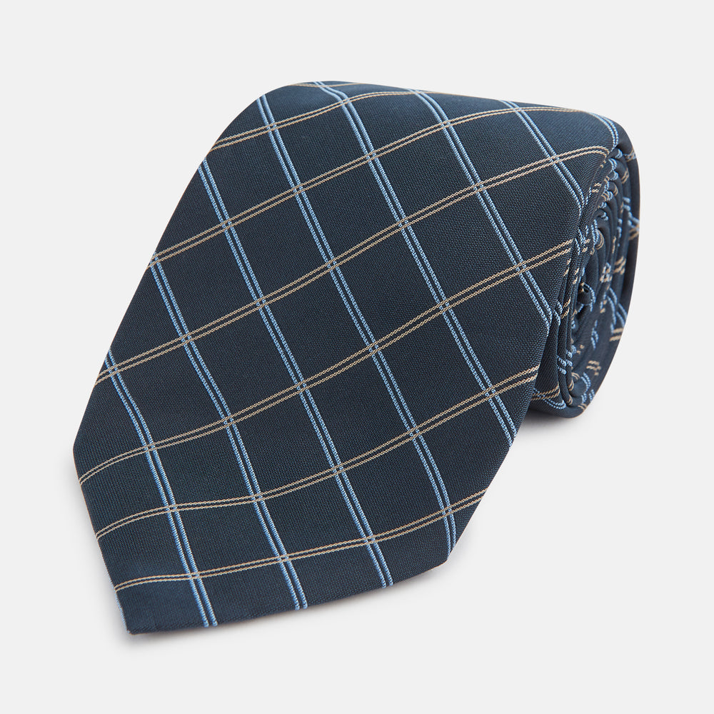 The Turnbull & Asser Navy Fine Double Check Silk Tie, featuring a refined navy, light blue, and tan plaid, is neatly rolled on a white background—an ideal accessory to complement any Turnbull & Asser shirt.