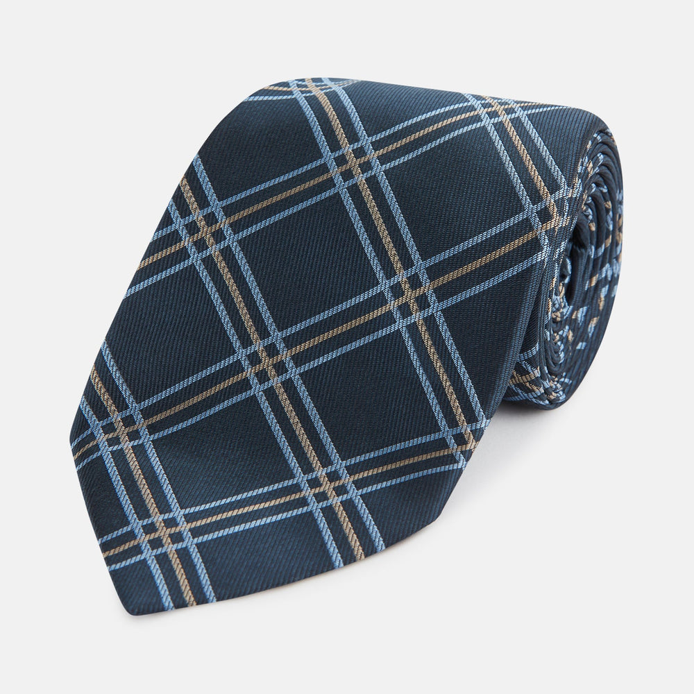 The Turnbull & Asser Navy Triple Check Silk Tie features a light blue and white plaid pattern—an essential accessory for the modern gentleman and a perfect complement to any Turnbull & Asser shirt.