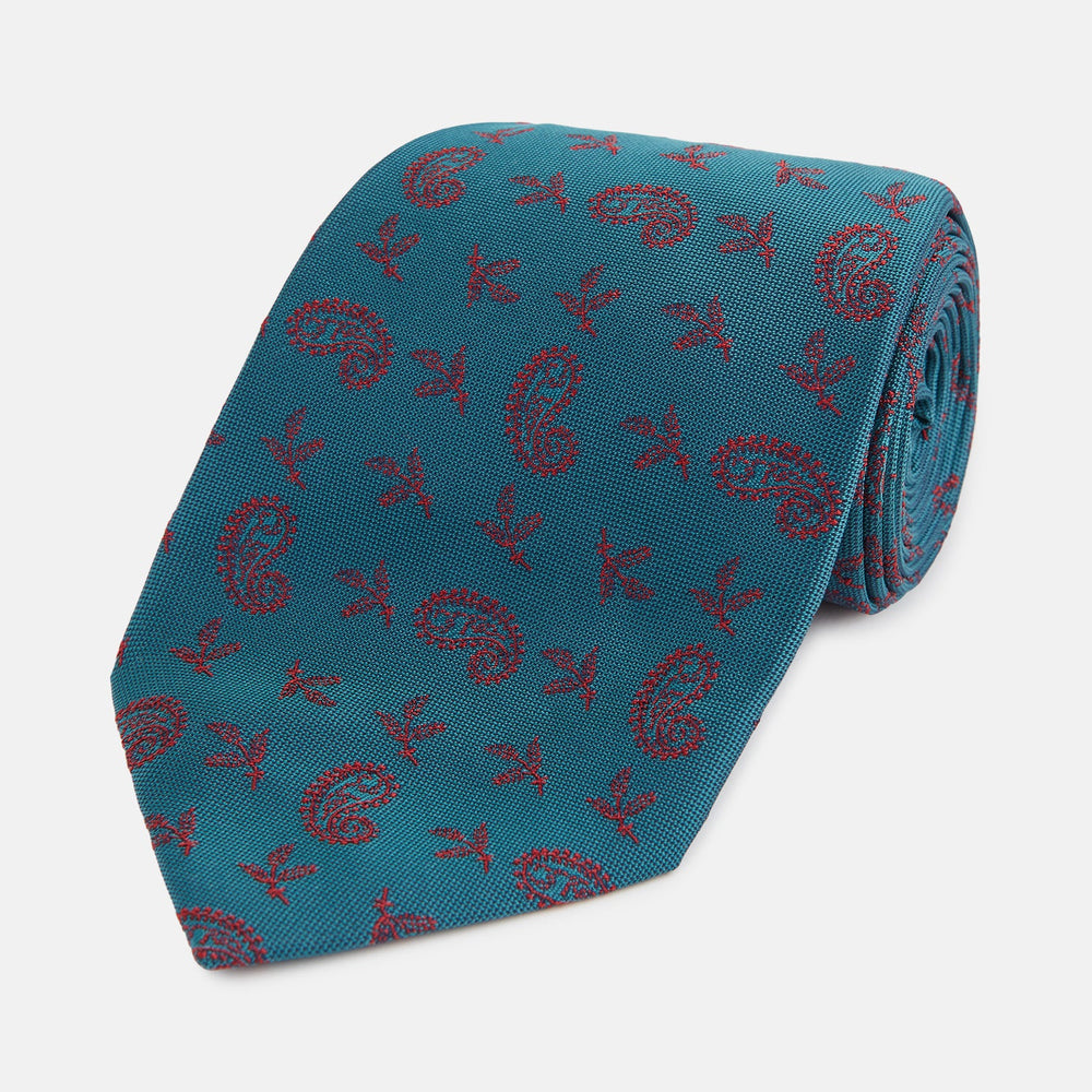 The Teal Paisley Silk Tie by Turnbull & Asser features a red paisley and small floral pattern, shown rolled with the pointed end forward on a white background.