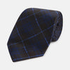 View 1 of product A rolled-up Green Tartan Silk Tie by Turnbull & Asser, featuring a classic tartan pattern on green silk and displayed against a light background—an elegant accessory to pair with Turnbull & Asser shirts.