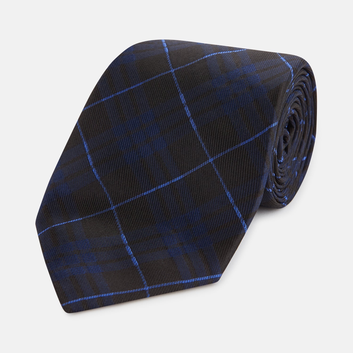 View 1 of product A rolled-up Green Tartan Silk Tie by Turnbull & Asser, featuring a classic tartan pattern on green silk and displayed against a light background—an elegant accessory to pair with Turnbull & Asser shirts.
