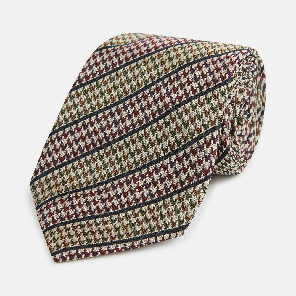The Turnbull & Asser Brown Puppytooth Stripe Silk Tie features a brown, burgundy, and cream houndstooth pattern with black and white diagonal stripes—ideal for pairing with Turnbull & Asser shirts.