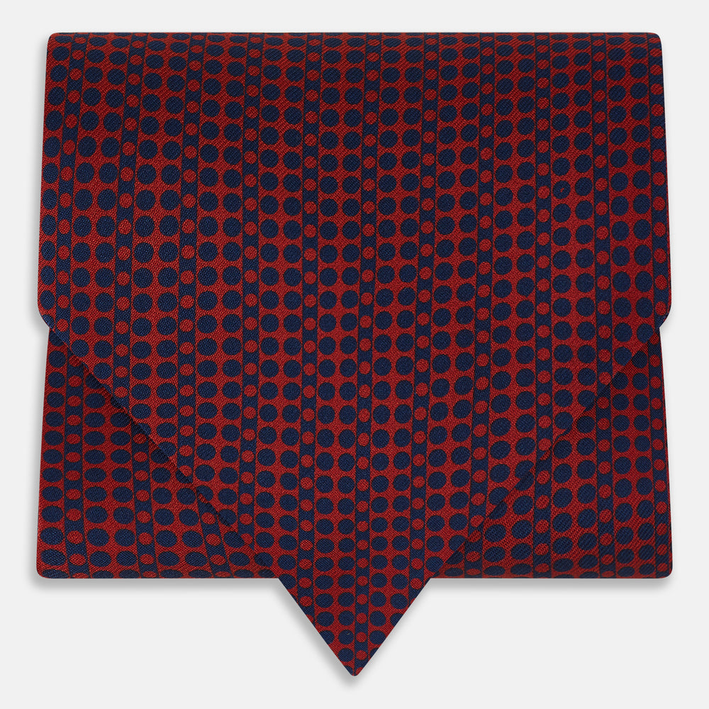 The Red Micro-Dot Bar Printed Silk Cravat from Turnbull & Asser UK features a geometric red and navy micro-dot pattern—a refined accessory inspired by classic British style, perfect for elegant weddings.