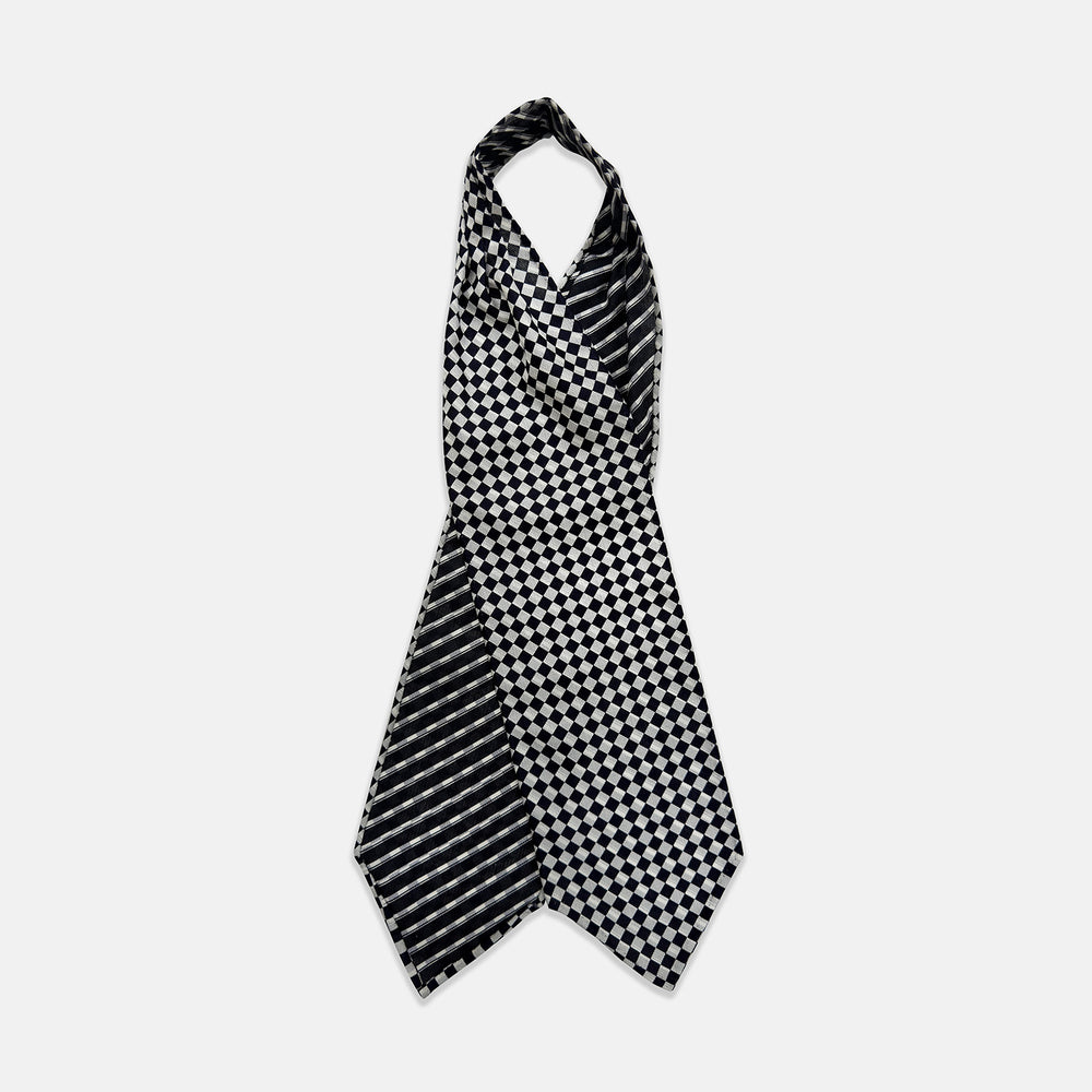 A Chequered Navy & White Cravat in Silk by Turnbull & Asser UK, featuring a checkered pattern on one side and diagonal stripes on the other, is laid flat on a white background.