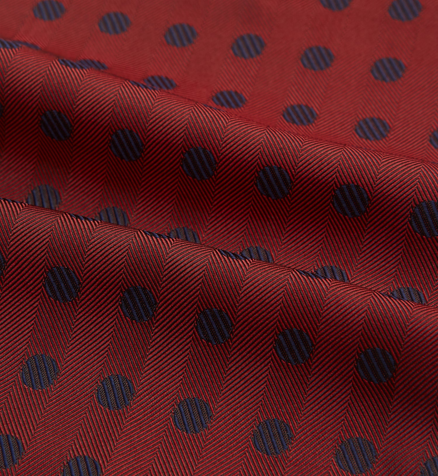 View 4 of product The Turnbull & Asser Red Dot Silk Cravat is a red silk accessory with evenly spaced dark blue polka dots—neatly folded for a sharp finish and perfect for pairing with your favorite handmade neckwear.