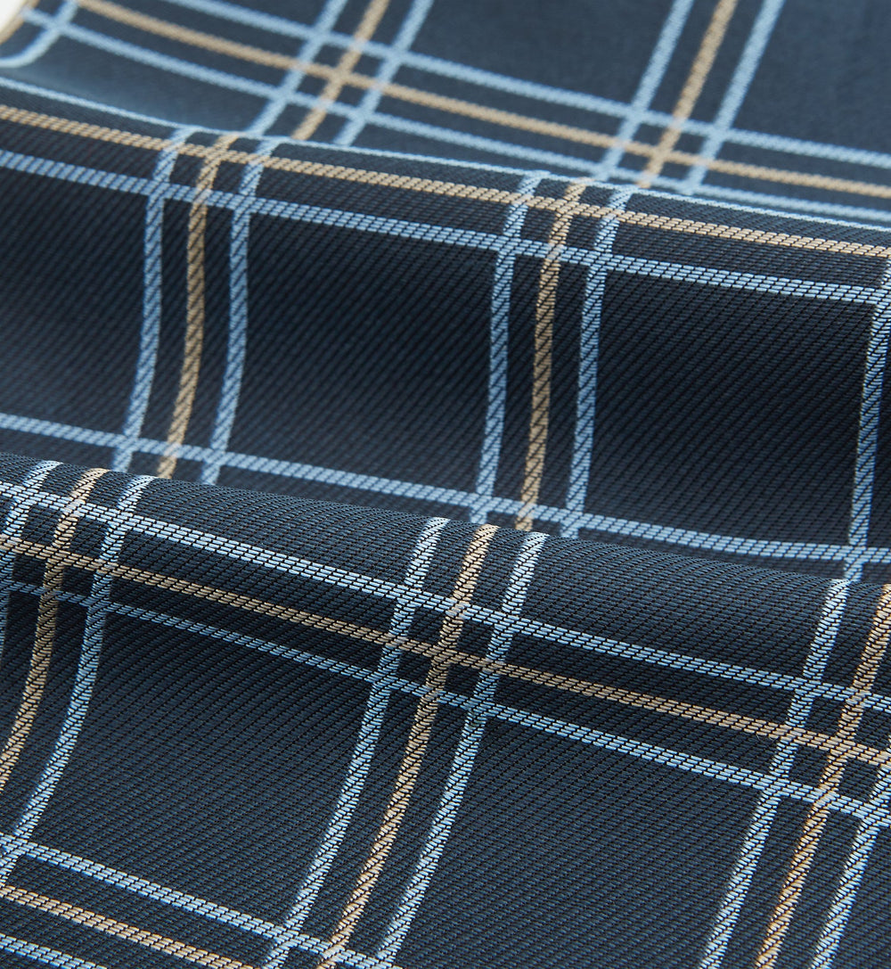 The Turnbull & Asser Navy Triple Check Silk Cravat features a classic navy, white, and light blue plaid design—perfect for adding elegance to any outfit. Shown neatly folded on a white background.
