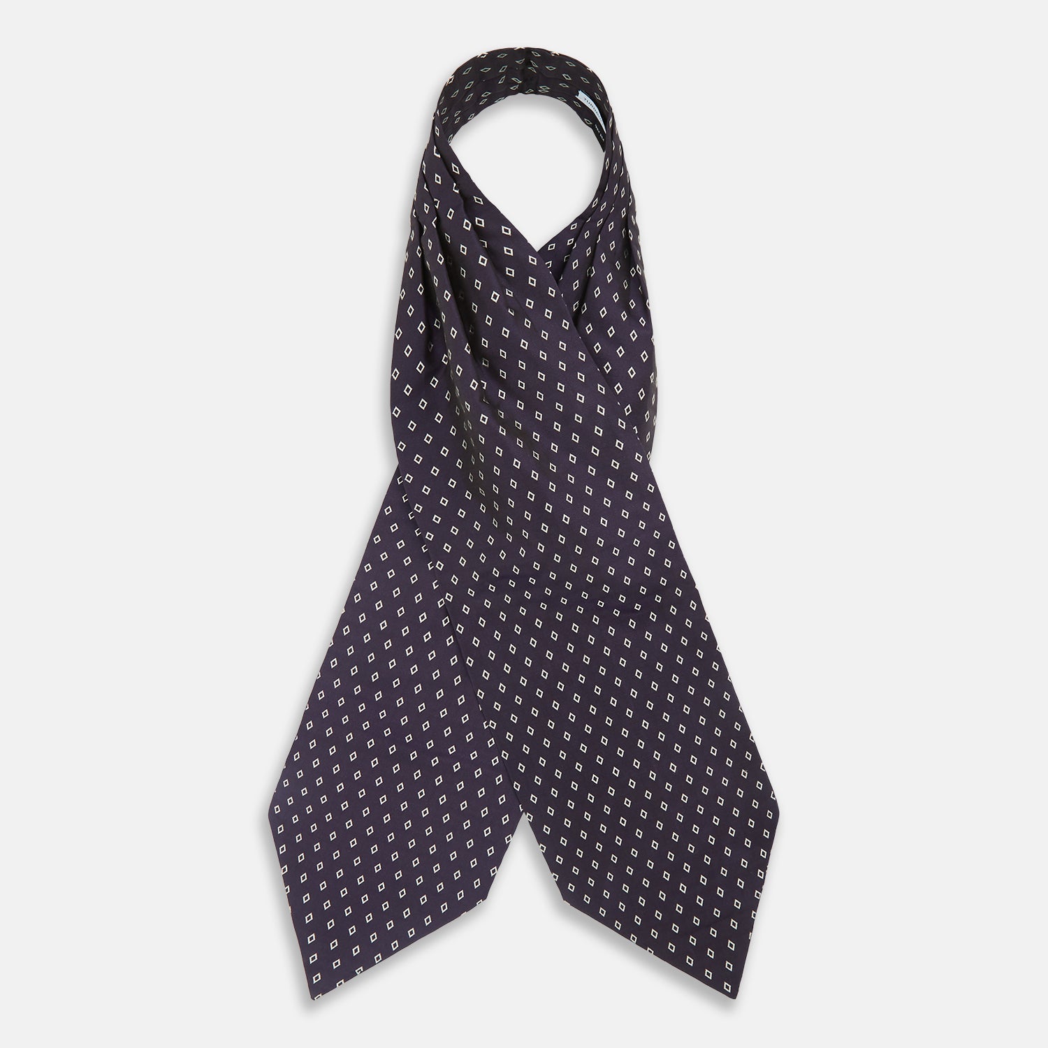 View 2 of product The Turnbull & Asser Blue Diamond Silk Cravat is a refined men's formal accessory, featuring a navy blue base with small white diamond patterns—perfectly complemented by a neatly folded, pointed-corner pocket square.