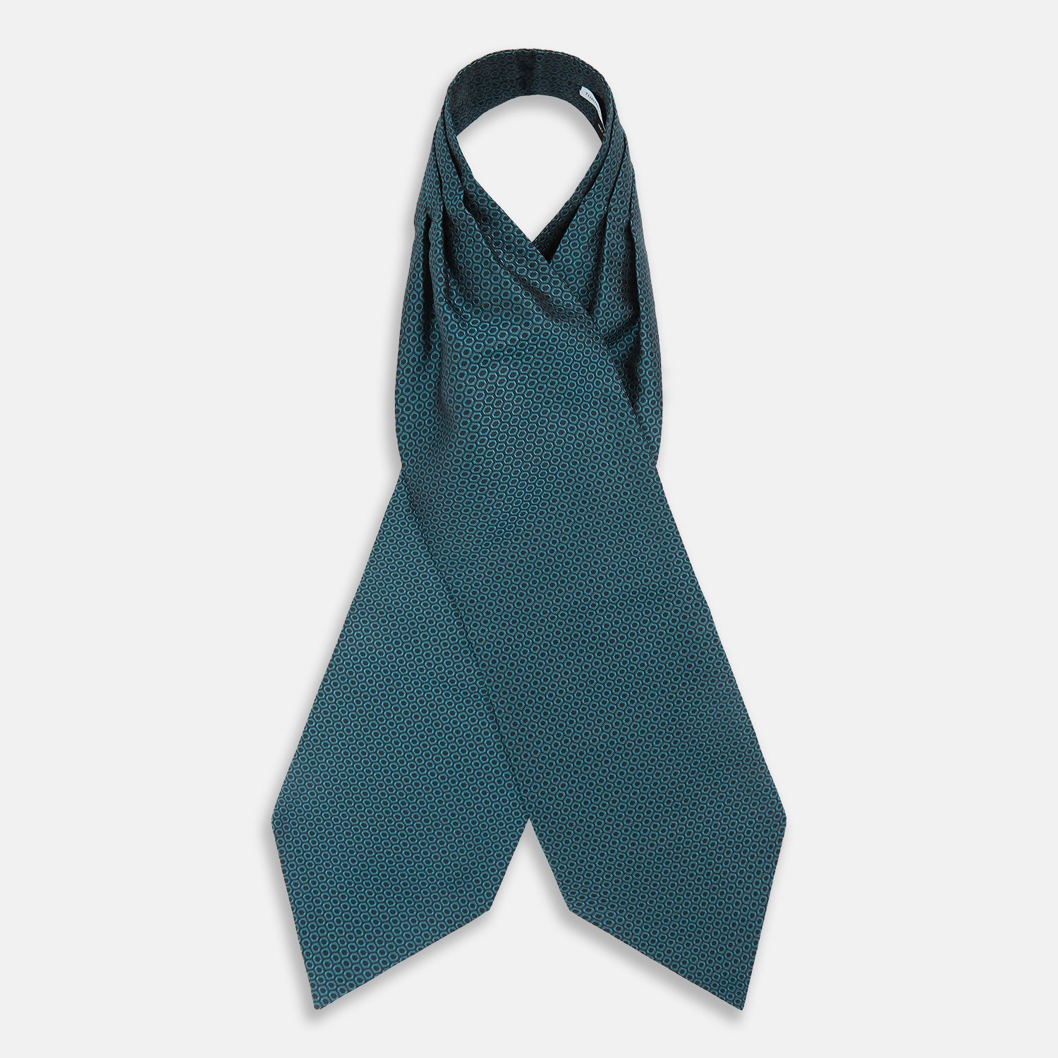 View 2 of product The Turnbull & Asser Turquoise Micro Hexagon Cravat is neatly folded to show a triangular point, displayed with a matching pocket square featuring a subtle hexagon pattern, all set against a white background.