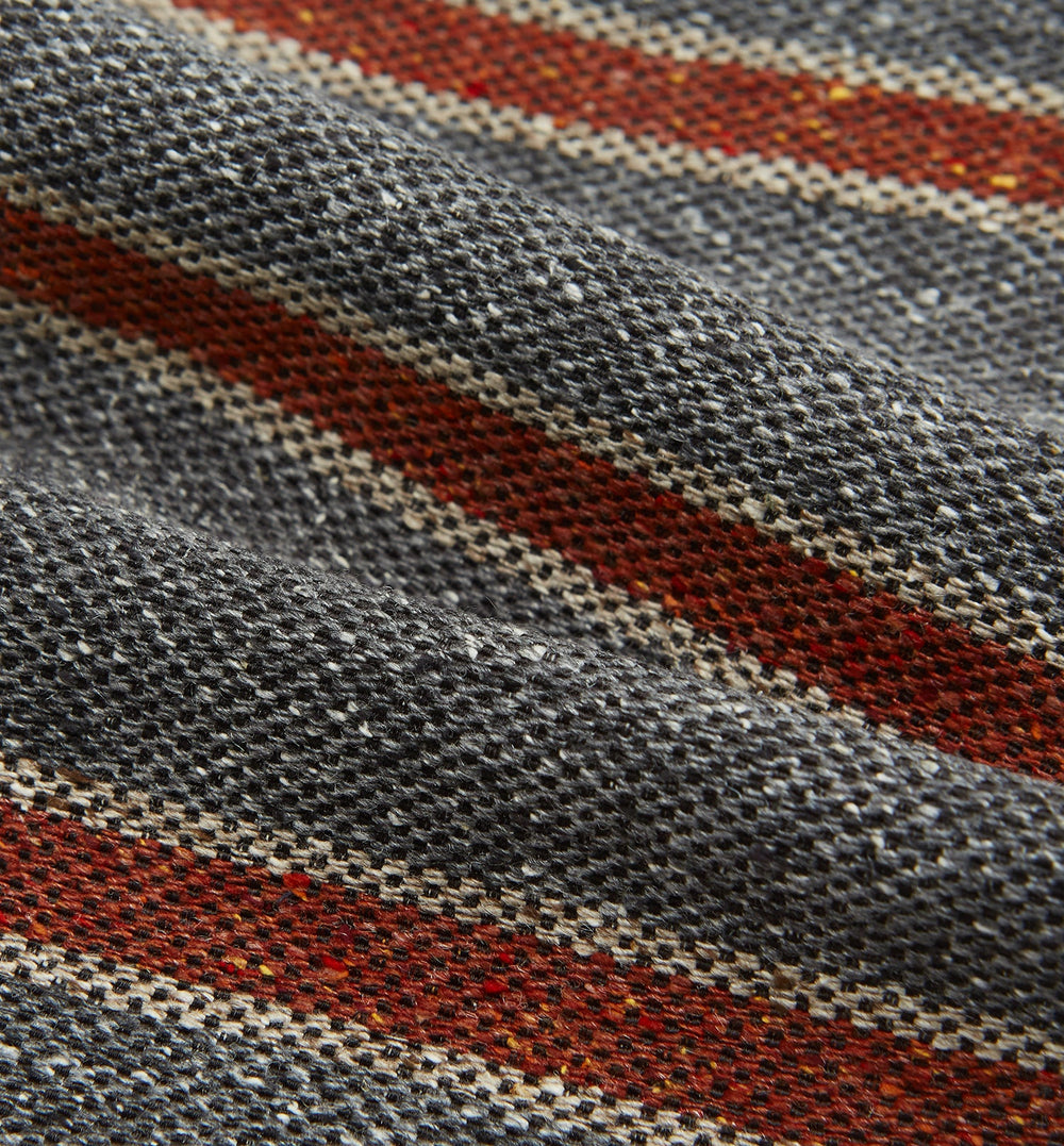The Red Block Stripe Silk Cravat by Turnbull & Asser features gray textured fabric with two bold red-orange stripes and a pointed tip, reminiscent of handmade neckwear, shown against a white background.