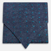 View 1 of product The Teal Micro Dot Silk Cravat by Turnbull & Asser is a formal accessory in textured dark blue silk, with small turquoise polka dots and a pointed edge at the bottom.