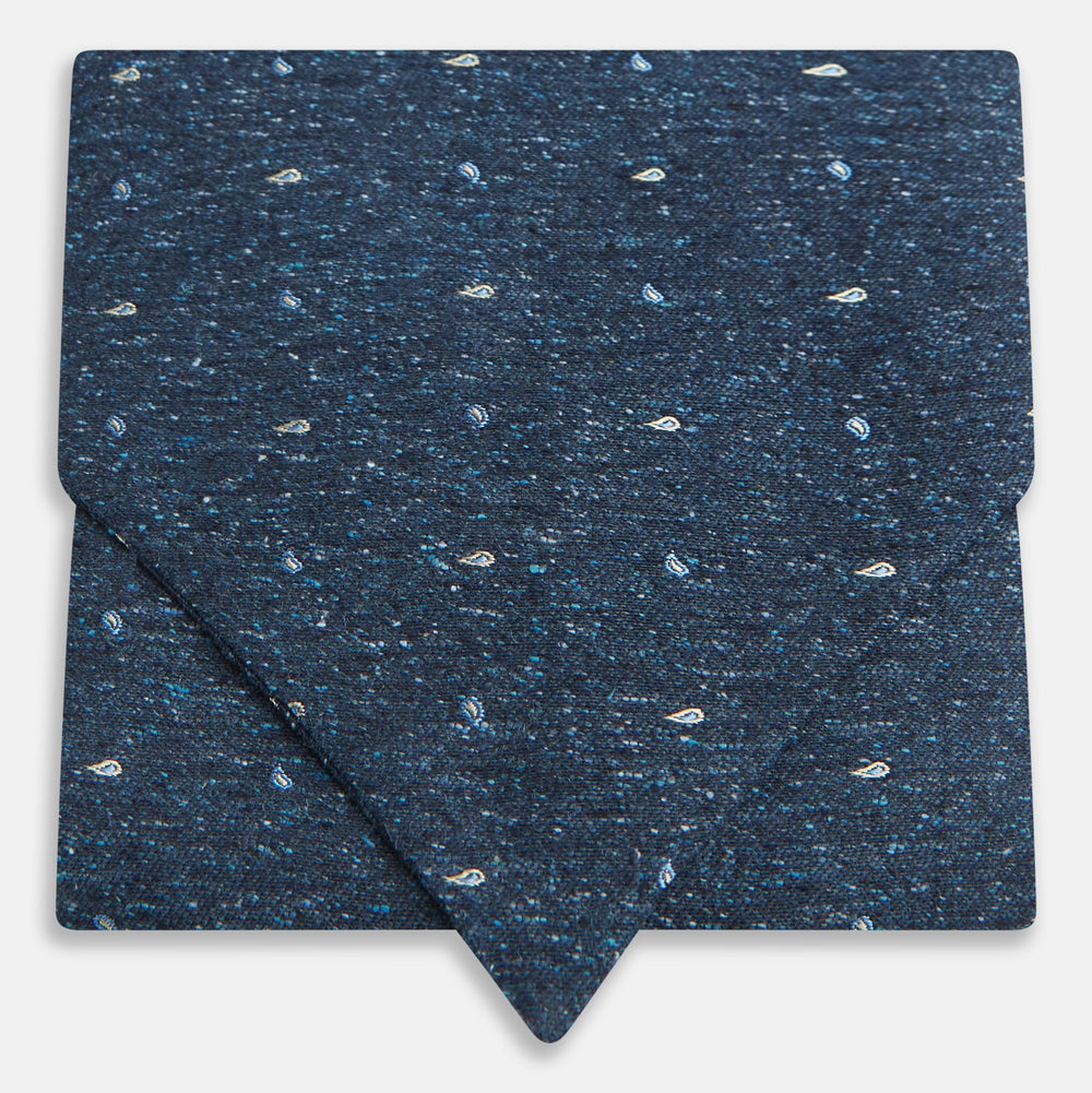 The Navy Micro Paisley Silk Cravat by Turnbull & Asser is a refined men's accessory, featuring subtle white paisley on silk—perfectly paired with a dark blue pocket square for an elegant formal look.