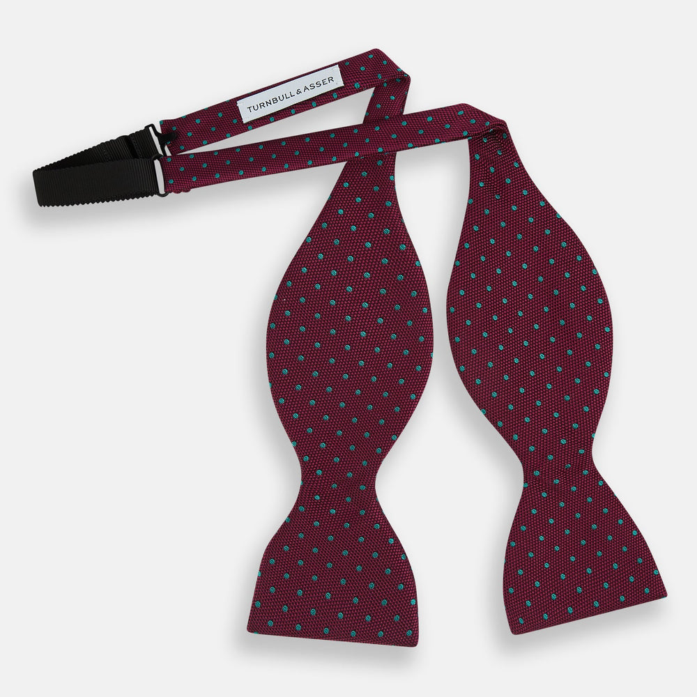 The Turnbull & Asser Green and Magenta Spot Silk Bow Tie, shown on a plain white background, features small, evenly spaced spots—making it an ideal accessory for elevating smart outfits.