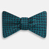 View 1 of product Turnbull & Asser's Turquoise Geometric Silk Bow Tie showcases British elegance with its teal and black cube pattern, set against a white background.