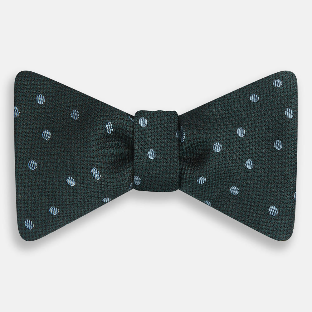The Turnbull & Asser Pale Blue and Green Micro Dot Silk Bow Tie features a refined micro dot pattern, blending pale blue and green hues for a touch of British elegance, shown on a white background.