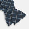 View 3 of product The Turnbull & Asser Navy Triple Check Silk Bow Tie features a navy, light blue, and beige plaid pattern on white, offering British elegance for those who value formal style.