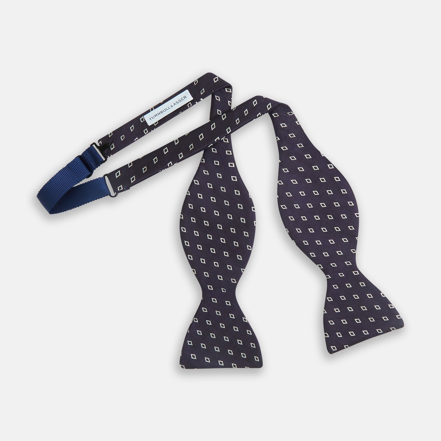 View 2 of product The Turnbull & Asser Blue Diamond Silk Bow Tie features small white diamond motifs on dark navy—perfect for adding classic British elegance to your formal look.