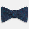 View 1 of product The Turnbull & Asser Teal Micro Dot Silk Bow Tie features textured navy blue silk with small teal dots, showcasing British elegance against a white background.
