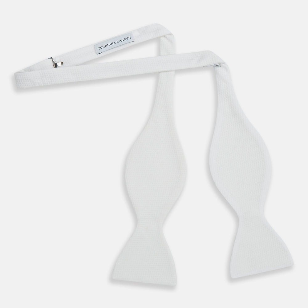 The Turnbull & Asser White Marcella Bow Tie features a classic shape and textured finish, ideal for formal occasions and elegantly presented against a plain white background.
