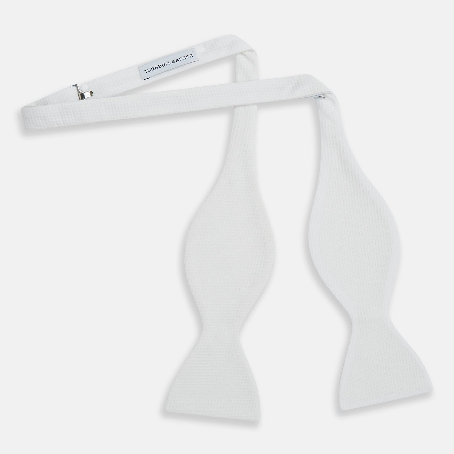 View 2 of product The Turnbull & Asser White Marcella Bow Tie features a classic shape and textured finish, ideal for formal occasions and elegantly presented against a plain white background.