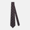 View 2 of product The Tomorrow Never Dies Seven-Fold Silk Tie by Turnbull & Asser UK features a geometric pattern of navy and brown squares with light blue diamond accents, rolled up and displayed on a plain white background.