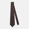 View 3 of product The Turnbull & Asser UK Tomorrow Never Dies Seven-Fold Silk Tie, as seen on James Bond, features a navy blue and brown geometric diamond pattern with silver squares at the center, set on a light background.