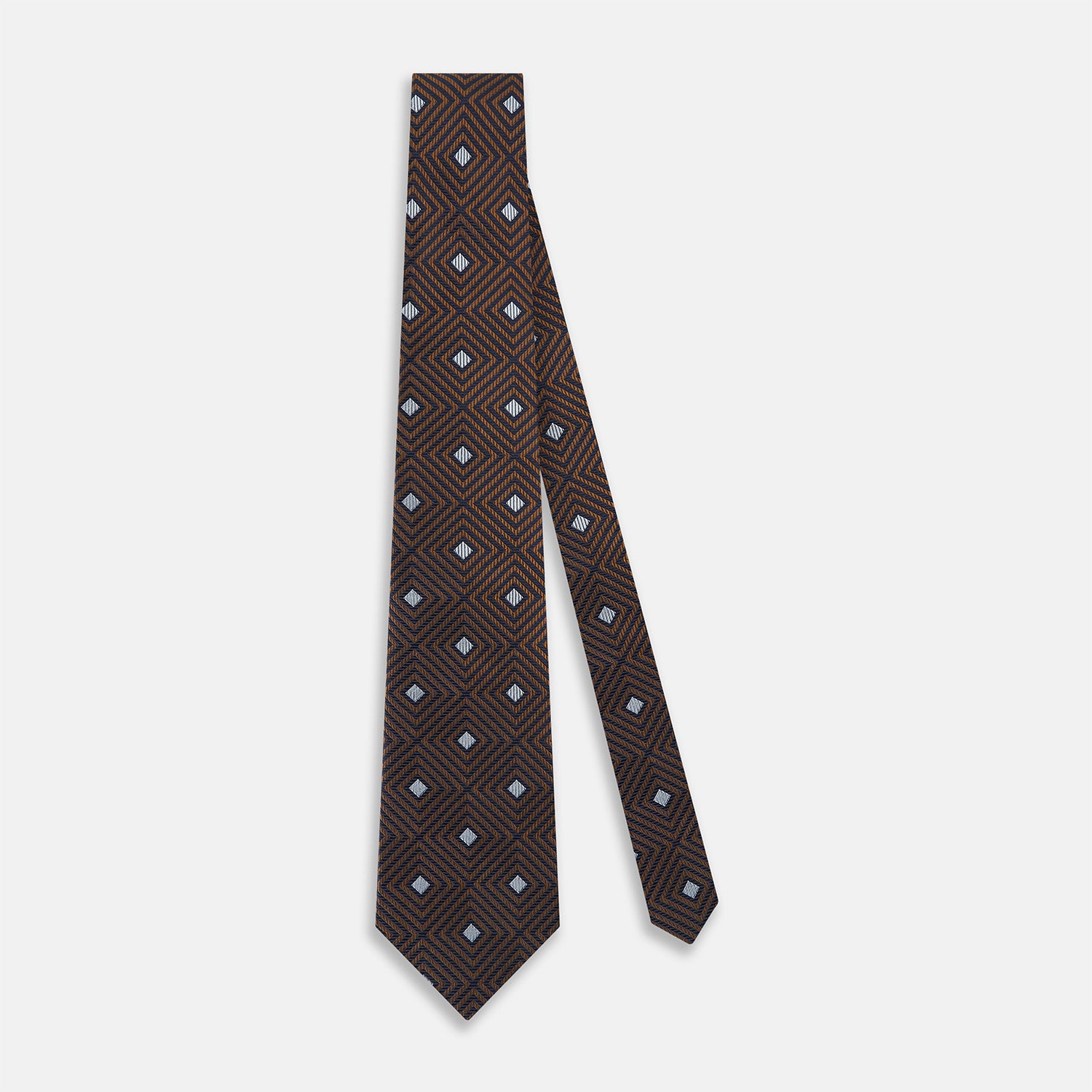 View 3 of product The Turnbull & Asser UK Tomorrow Never Dies Seven-Fold Silk Tie, as seen on James Bond, features a navy blue and brown geometric diamond pattern with silver squares at the center, set on a light background.