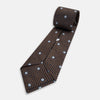 View 6 of product The Turnbull & Asser UK Tomorrow Never Dies Seven-Fold Silk Tie, as seen on James Bond, features a navy blue and brown geometric diamond pattern with silver squares at the center, set on a light background.