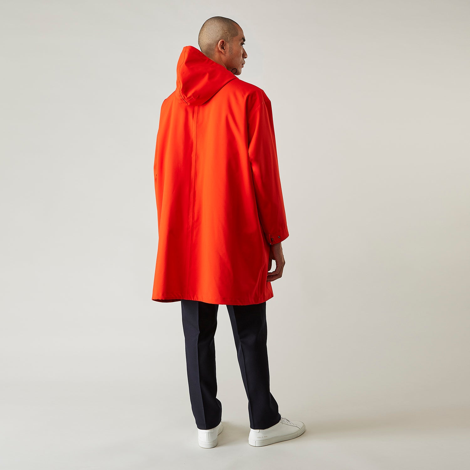 View 4 of product Wearing the Turnbull & Asser Red Walter Sealup Parka with Detachable Liner, black pants, and white sneakers, a person stands in profile against a plain light background—perfect for travel.