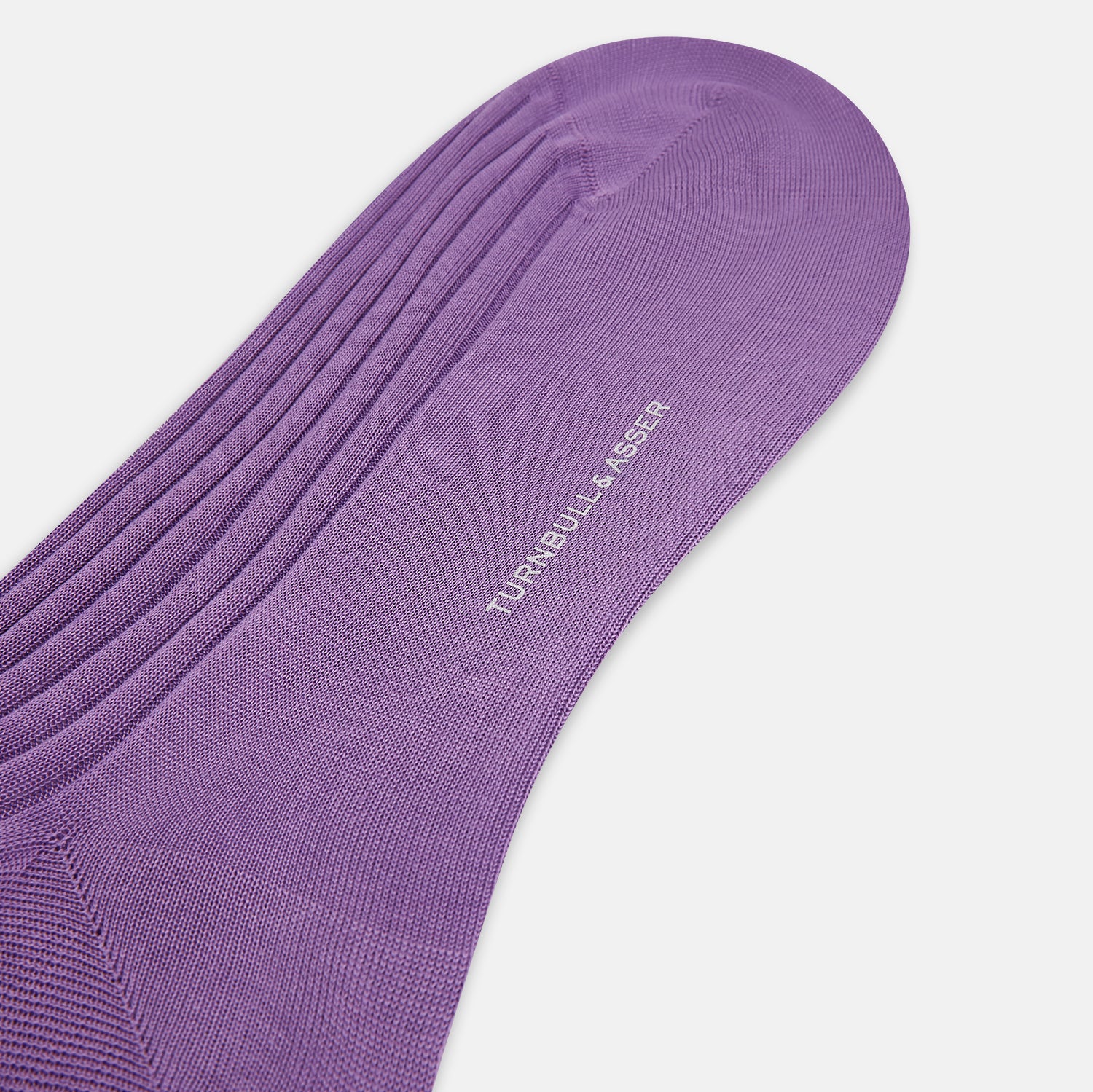 View 3 of product The Turnbull & Asser Violet Long Sock, crafted from mercerised Egyptian cotton, is shown in side profile against a white background, highlighting its knee-high length and ribbed texture.