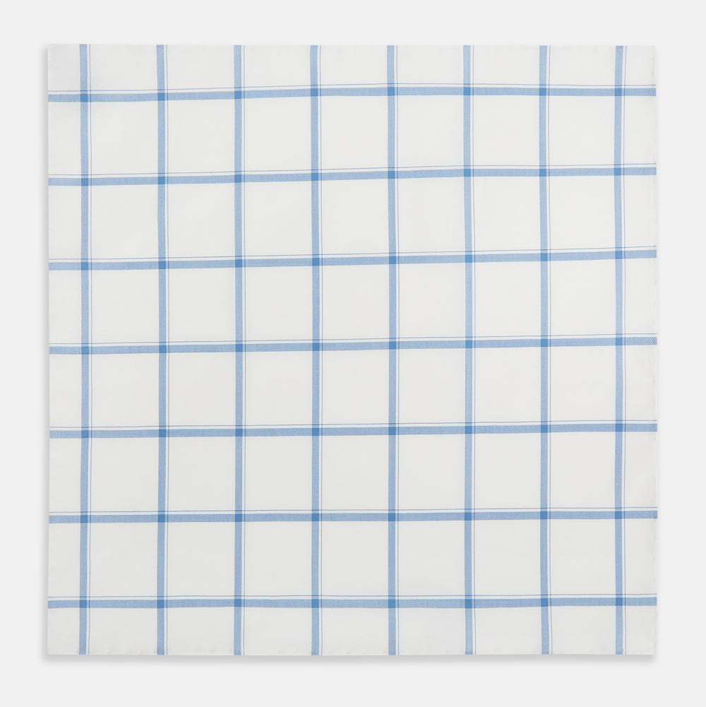 The Turnbull & Asser Colony Blue Grid Check Hand-Rolled Handkerchief features a white base with intersecting light and dark blue plaid lines forming squares, shown folded on a plain white background.
