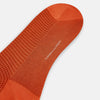 View 3 of product The Orange Houndstooth Mid-Length Socks by Turnbull & Asser feature a bold houndstooth pattern with solid orange toe, heel, and cuff, crafted from soft cotton and shown against a plain white background.