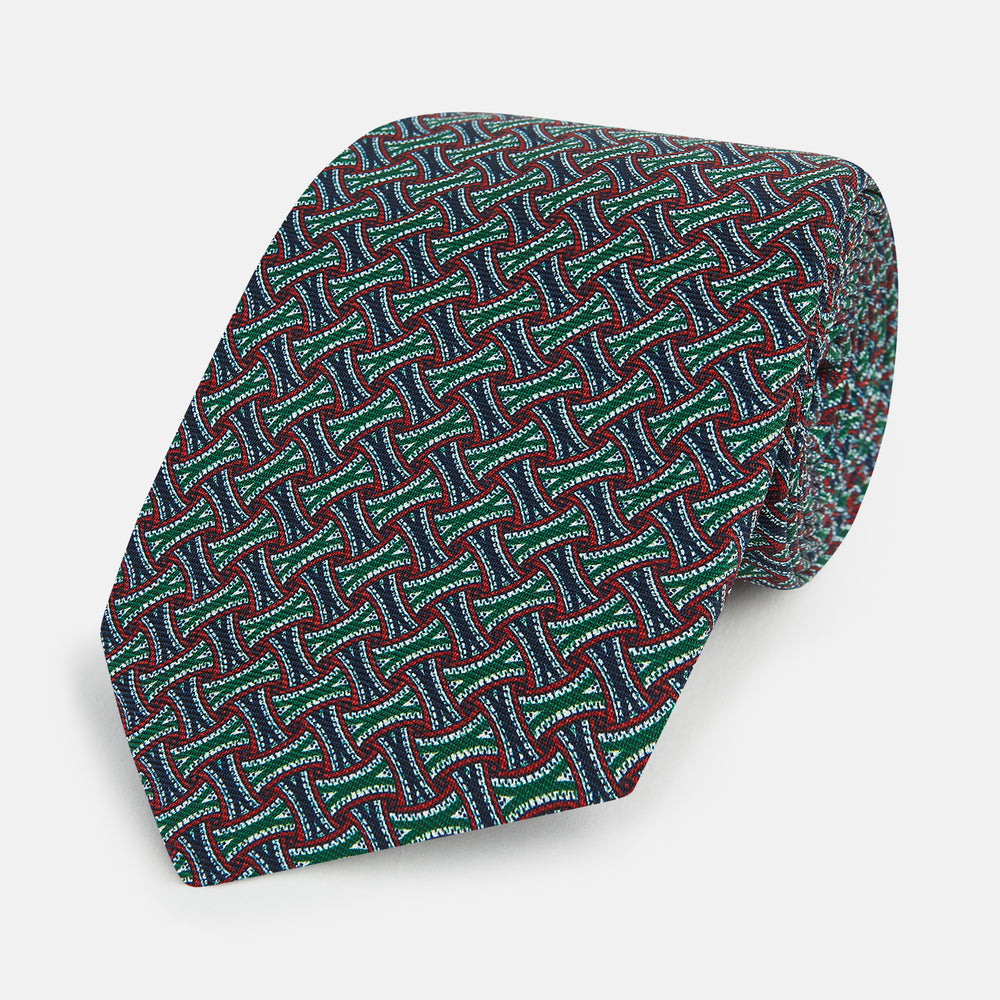 The Forest Green and Red Weave-Patterned Printed Silk Tie by Turnbull & Asser features an intricate geometric motif in red, green, blue, and white, crafted from luxurious English silk for classic sophistication.