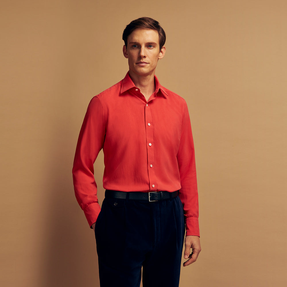 The Turnbull & Asser Coral Pink Silk Regular Fit Mayfair Shirt features long sleeves, a classic collar, and white buttons, displayed laid flat on a plain white background.