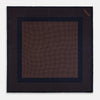 View 3 of product The Navy and Blush Dot Silk Pocket Square by Turnbull & Asser features a navy base with small orange polka dots and a border, shown neatly folded with one corner flipped over.